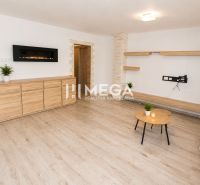 Wohnzimmer in einer 3-Zimmer-Wohnung mit Holzboden, hellen Wänden und Möbeln.