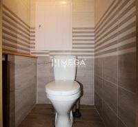 Badezimmer in einer 3-Zimmer-Wohnung mit Fliesen und einem Boden in Holzoptik.