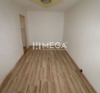 Ein Zimmer in einer 3-Zimmer-Wohnung mit einem Boden in Holzoptik und weißen Wänden.
