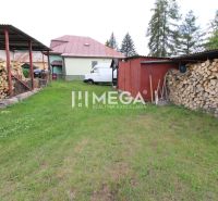 Der Hof des Einfamilienhauses in Ulič, Ulič 131, Rasen, gelagertes Holz und Unterstand.