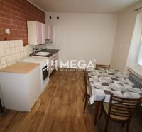 Küche in einer 2-Zimmer-Wohnung mit Holzboden, Esstisch und Kochbereich.