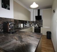 Küche in einer 2-Zimmer-Wohnung mit dunklem Marmordekor und Holzboden.
