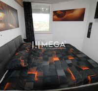 Schlafzimmer in einer 2-Zimmer-Wohnung mit Bett und künstlerischen Dekorationen an der Wand.