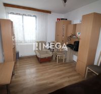 Ein Zimmer mit Holzelementen, Möbeln, einem Sessel und einem Tisch in einem Einfamilienhaus.