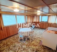 Interieur eines Einfamilienhauses mit Holzwänden, einem Tisch und einem Kinderbett.