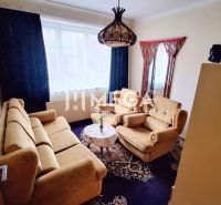 Wohnzimmer in einem Einfamilienhaus mit beigen Sofas, Teppich und Kronleuchtern.