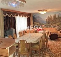 Wohnzimmer in einem Einfamilienhaus mit Teppich, Fototapete und rundem Tisch.