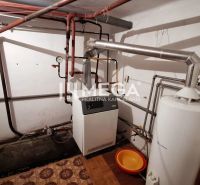 Heizraum mit Boiler und Rohrleitungen in einem Einfamilienhaus, Boden mit Holzdekor.