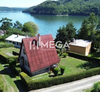 Ein Ferienhaus am Stausee in Nová Kelča, umgeben von Grün und einem gepflegten Garten.