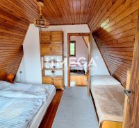 Das Innere der Hütte mit Holzverkleidung, einem Doppelbett und einem Einzelbett.