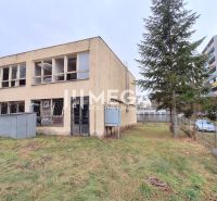 Das Gebäude in der Tyršova-Straße in Humenné, im Hintergrund Wohnblöcke mit Bäumen.