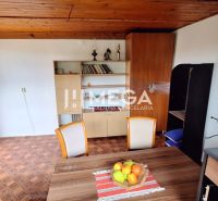 Innenraum einer Hütte mit Holzdekor, Retro-Möbeln und Esstisch.