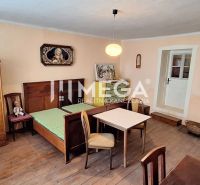 Ein Zimmer in einem Einfamilienhaus mit einem Bett, Möbeln und einem Boden mit Holzdekor.