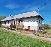 Ein Einfamilienhaus in der Gemeinde Zbudská Belá, umgeben von grünen Rasenflächen und Bäumen.