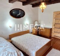 Schlafzimmer mit zwei Betten, Holzbalkendecke und Holzboden in einem Einfamilienhaus.