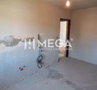 Ein leerer Raum in einer Zweizimmerwohnung mit unvollendeten Putzarbeiten und Elektroinstallationen.