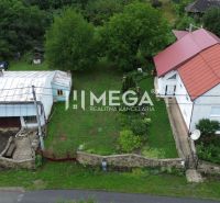 Ein Haus mit rotem Dach in Oľšinkovo auf der Oľšinkov-Straße, umgeben von einem Garten. Grundstücke - Wohnen.