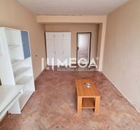 Wohnzimmer in einer 2-Zimmer-Wohnung mit weißen Möbeln und einem Boden in Holzoptik.