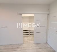 Innenraum eines Einfamilienhauses mit weißen Schiebetüren und einem Boden in Holzoptik.