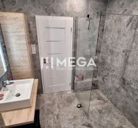Ein Badezimmer in einem Einfamilienhaus mit Steinverkleidung und einer Dusche.
