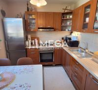 Küche in einer 3-Zimmer-Wohnung mit Holzelementen und Esstisch.