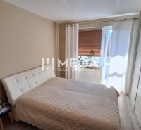 Schlafzimmer mit großem Bett, Kleiderschrank und Holzboden in einer 3-Zimmer-Wohnung.