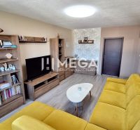 Wohnzimmer mit Holzboden, gelbes Sofa, Holzmöbel.
