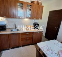 Küche in einer 3-Zimmer-Wohnung mit Holzschränken und Esstisch.