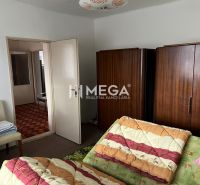 Ein Schlafzimmer in einem Einfamilienhaus mit Bett, Einbauschrank und offenen Türen.