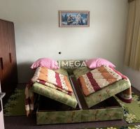 Ein Schlafzimmer in einem Einfamilienhaus mit zwei Betten, einem grünen Teppich und einem Bild an der Wand.