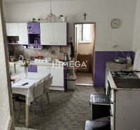 Küche in einem Einfamilienhaus mit violetten Schränken und Esstisch.