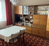 Esszimmer in einem Einfamilienhaus mit Retro-Möbeln, Teppich, Kronleuchter, Vorhänge.