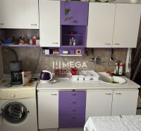 Eine Küche in einem Einfamilienhaus mit violetten und weißen Schränken, einer Kaffeemaschine und einer Spülmaschine.