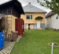Ein Einfamilienhaus in der Jesenského-Straße in Snina, mit grünem Rasen und Zubehör.