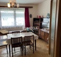 Esszimmer eines Einfamilienhauses mit Holzboden, Esstisch und Vitrine.