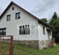 Ein Einfamilienhaus in Zboj mit einem Steinfundament und einem Garten, umgeben von Grün.