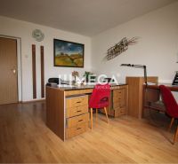 Ein Büro mit einem Boden in Holzoptik, Stühlen und Bildern an den Wänden.