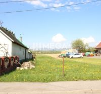 Grundstücke - Wohnen in Sačurov mit Häusern, Rasen und Verkehrsschild.