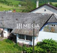 Ein altes Gebäude auf Wohnbaugrundstücken in Ondavské Matiašovce, umgeben von Grün.
