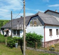 Ein älteres Haus mit Holzelementen im grünen Ondavské Matiašovce, ideal für Grundstücke - Wohnen.