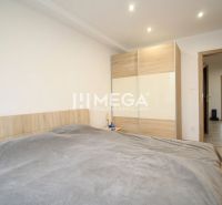 Ein Zimmer einer 3-Zimmer-Wohnung mit einem Bett, einem Kleiderschrank und einem Boden mit Holzdekor.
