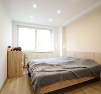 Schlafzimmer in einer 3-Zimmer-Wohnung mit Holzboden und einfach eingerichteten Interieur.