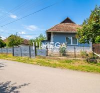Ein Einfamilienhaus in Veľká Ida mit blauer Fassade und Garten, umgeben von einem Zaun.