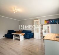 Wohnzimmer in einem Einfamilienhaus mit einem blauen Sofa und einem Boden in Holzoptik.