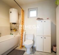 Badezimmer in einem Einfamilienhaus mit sanitären Einrichtungen und Aufbewahrungsschränken.