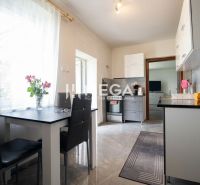 Küche in einem Einfamilienhaus mit Esstisch, Blumen und Geräten.