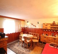 Das Innere der Hütte mit Holzeinrichtung, einem Sofa und einem Esstisch mit rustikalen Stühlen.