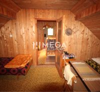Holzverkleidung der Wände, Sitzecke und einfache Betten in der Hütte.