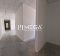 Der Flur im Büro mit weißen Wänden, Betonboden, abgehängter Decke.