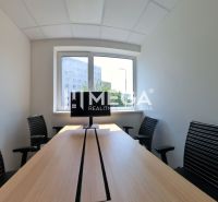 Büroinnenraum mit langem Tisch, vier Stühlen und einem Fenster.